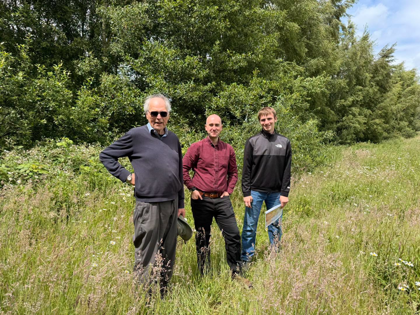Community visitors standing among grasses and wildflowers at Poringland Wildlife Meadow